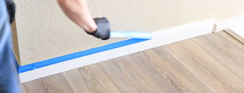 Remove masking tape from baseboard