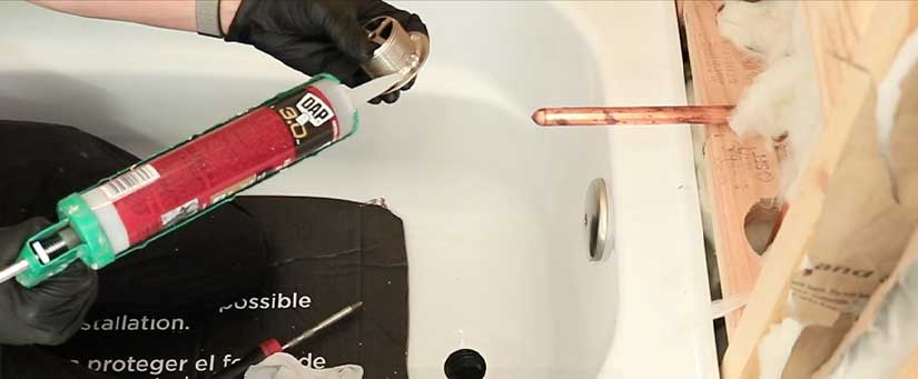 Applying silicone sealant to tub drain